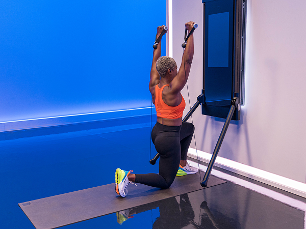 Tonal instructor doing half kneeling overhead press