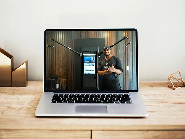Laptop on desk showing live video call with Tonal expert
